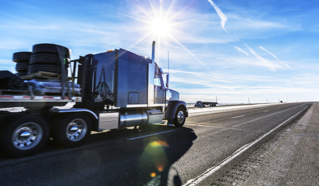 Expressway Flatbed Semi Trailer Trucks On Western USA Sunflare Highway 